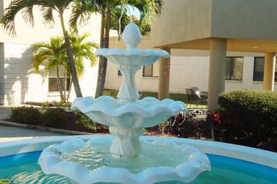 Outdoor fountain surrounded by palm trees