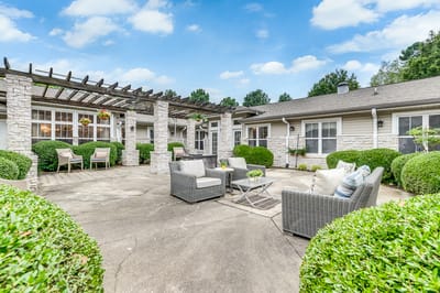 Patio seating area with greenery and comfortable furniture