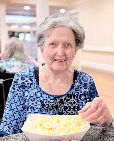Smiling resident enjoying popcorn in a communal area
