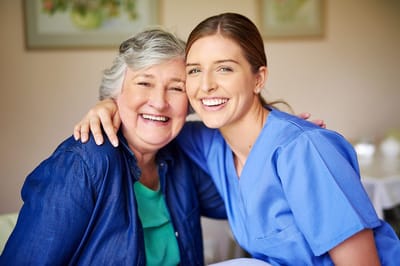 Fairhaven Healthcare Center for Rehabilitation and Nursing, Nursing Home in Lowell, MA — Smiling senior resident with a cheerful caregiver in a room