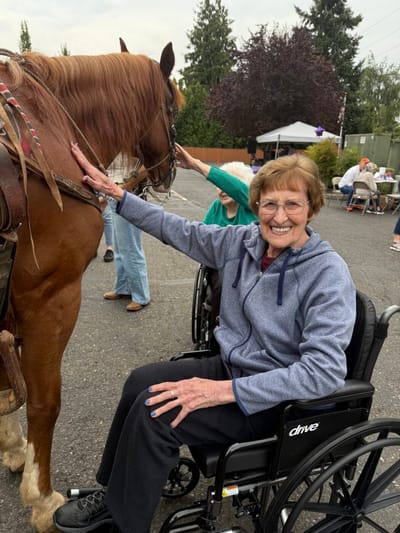 Resident interacting with a horse at an outdoor event