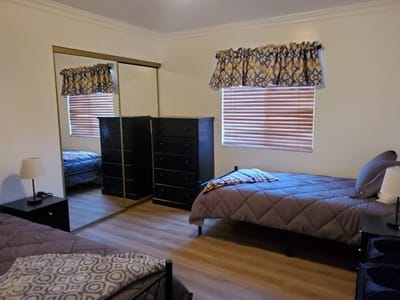 Private resident room with two beds and a dresser