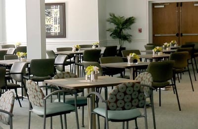 Bright dining room with tables set for residents