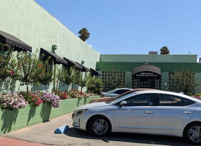 Exterior view of Arrowhead Healthcare Center with flowers and vehicles