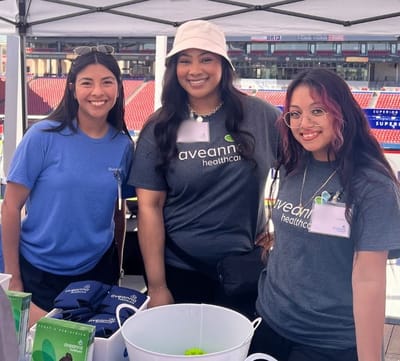 Three staff members posing at an event booth