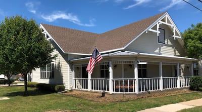 Exterior view of a senior living facility with an American flag