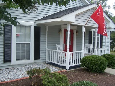 Exterior view of a building with a porch and flag