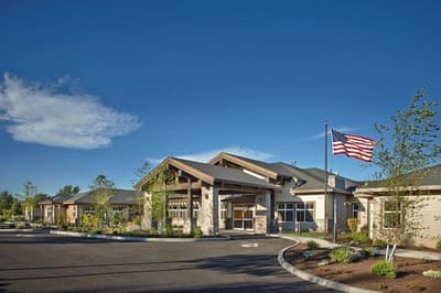 Exterior view of Bend Transitional Care facility with flag