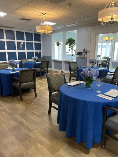 Dining room set up with blue tablecloths and flowers