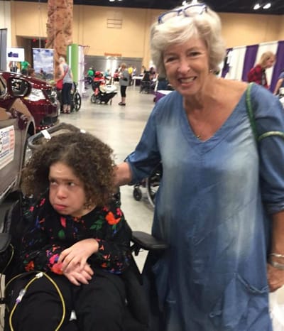 A woman posing with a resident in a facility setting