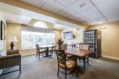 Common area with tables and chairs in a senior living facility