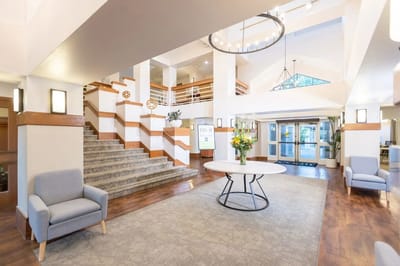 Bright and spacious lobby with seating and staircase