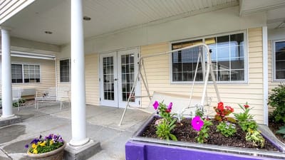 Outdoor patio area with flowers and swing set