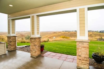 View from a covered patio overlooking grassy landscape