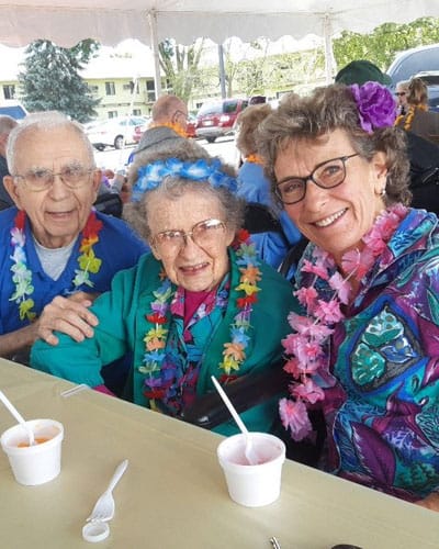 Happy residents celebrating with flowers and leis