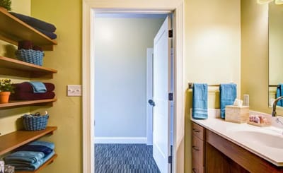 Well-designed bathroom with shelving and towels