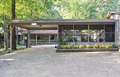 Exterior view of Green Oaks Inn with garden and porch area
