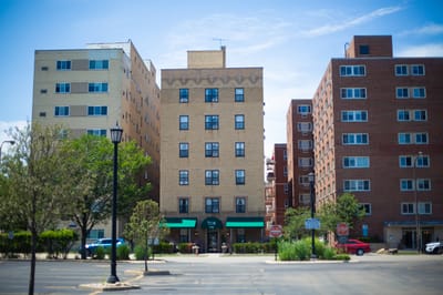 Exterior view of a senior living facility with green awnings