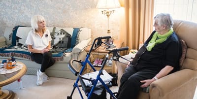 Caregiver talking with a resident in a cozy living area