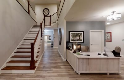 Bright lobby area with reception desk and staircase