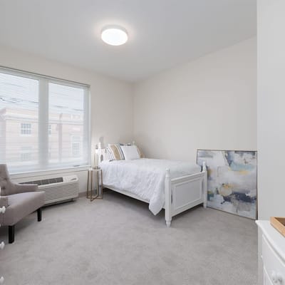 Bright private resident room with bed and artwork