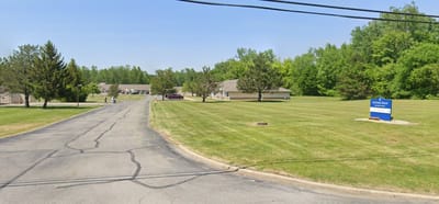 View of the facility exterior with green lawn and signage