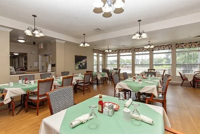 Dining room with green tablecloths and empty chairs