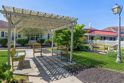 Outdoor seating area with shaded pergola and greenery