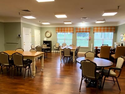 Interior view of a common area with tables and chairs.