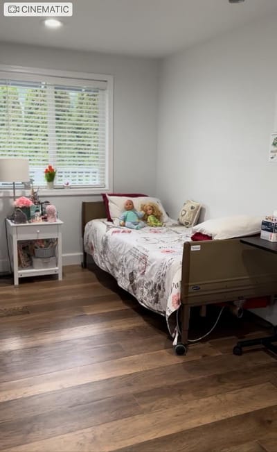 A cozy resident room with a hospital bed and dolls