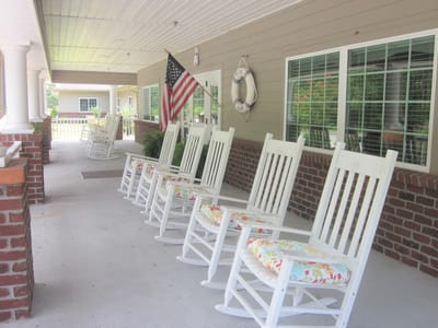 Outdoor seating area with rocking chairs and American flag
