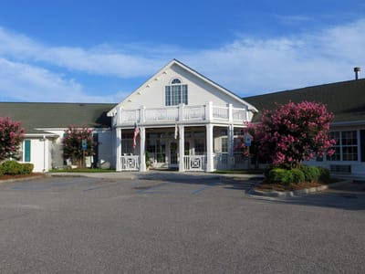Front exterior view of Pee Dee Gardens with flowering trees