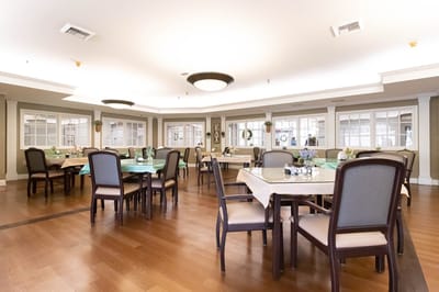 Bright dining room with tables and chairs set up