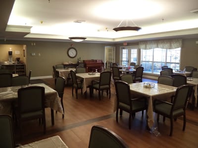 Dining room with tables and chairs arranged for residents
