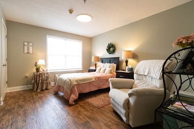 Cozy interior of a resident's room with a bed and chair