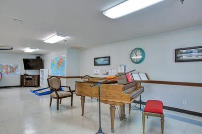 Interior activity room with a piano and maps