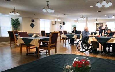Residents enjoying a communal dining area with tables set for meals