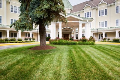 View of the entrance to Sunrise of Pikesville with landscaped grounds