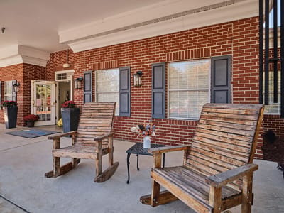 Front entrance of a senior living facility with rocking chairs