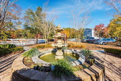 Beautiful outdoor fountain surrounded by gardens and trees