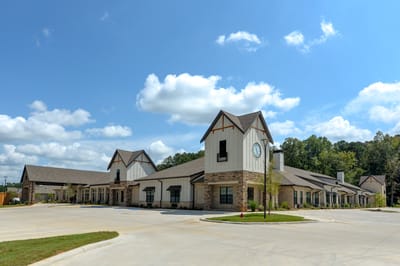 Exterior view of a senior living facility with gardens