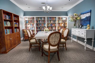 Cozy reading room with bookshelves and dining set