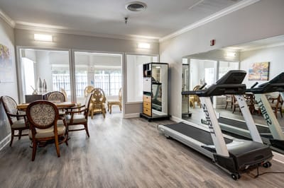 Interior fitness area with a treadmill and dining table