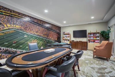 Interior game room with poker table and wall mural
