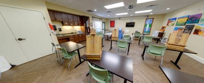 Art and crafts activity room with tables and easels