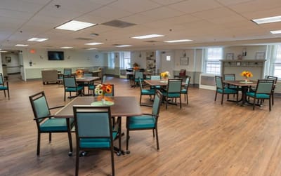 Bright common area with tables and chairs for residents