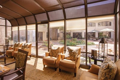 Sunlit common area with seating and garden view