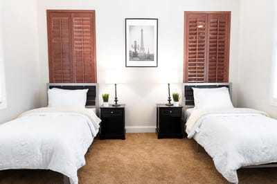 A shared resident room with two beds and lamps