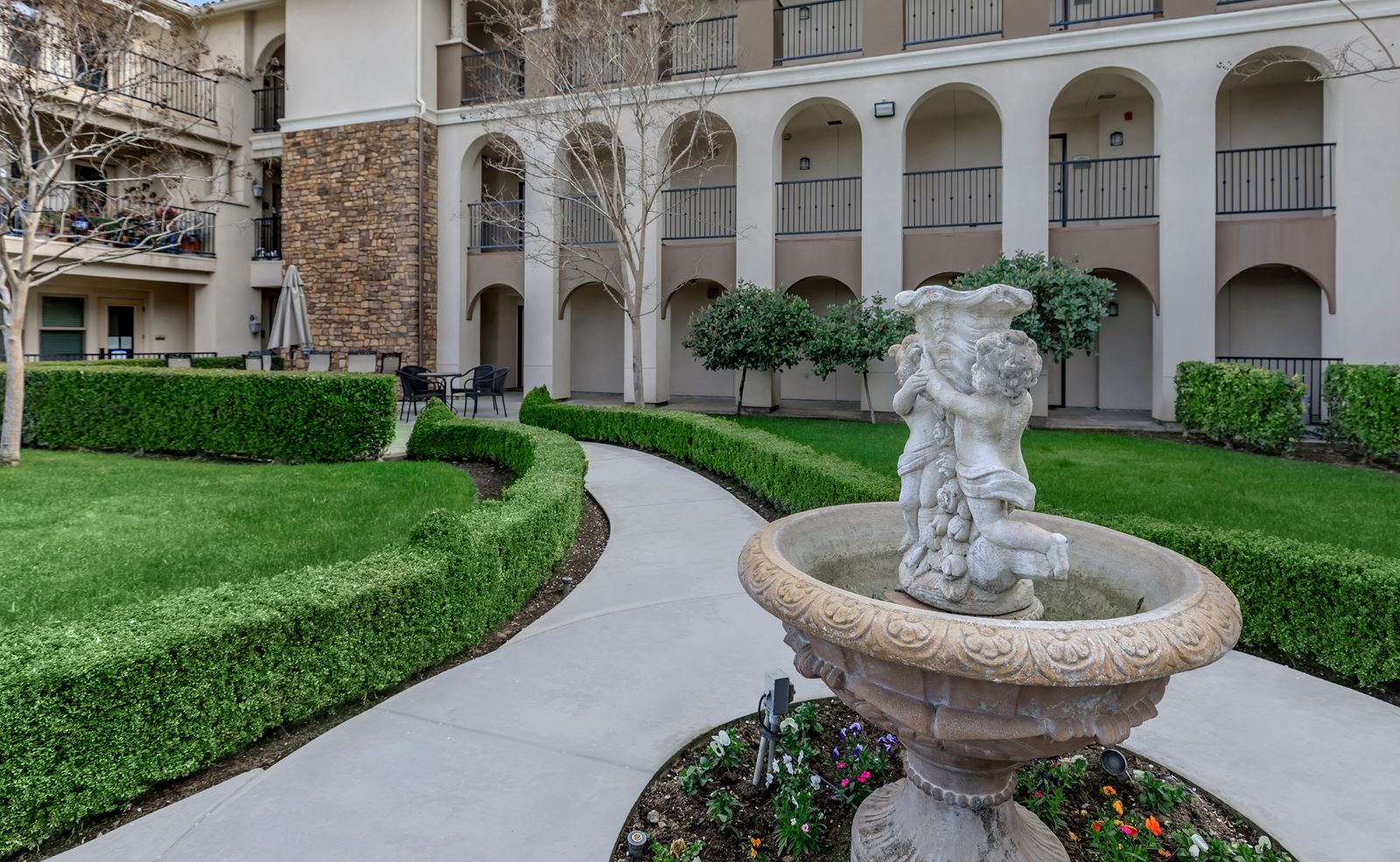 Garden area with a fountain and hedges