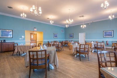 Bright dining room with chandeliers and tables set
